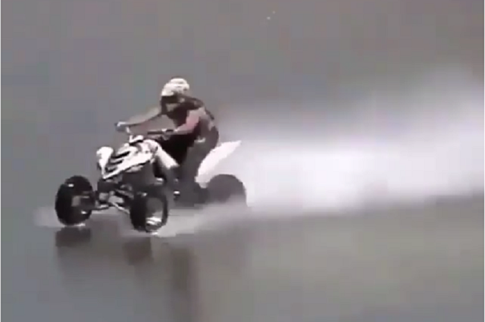 Biker melewati sungai dengan menggunakan motor ATV