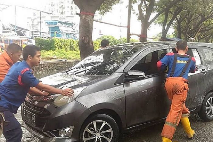 Daihatsu Sigra yang sedang dievakuasi petugas damkar