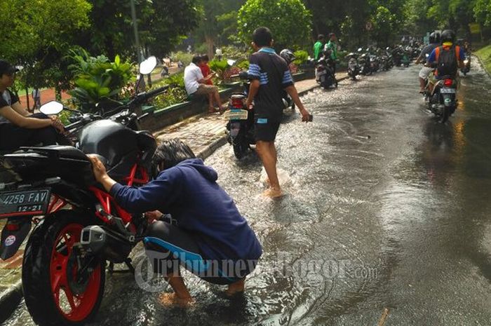 Pipa PDAM bocor dimanfaatkan warga untuk mencuci motor