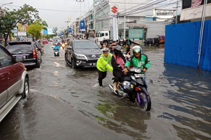 Polisi membantu warga dorong motor di Pekanbaru