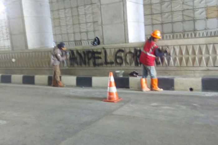 Petugas membersihkan coretan di underpass Mampang