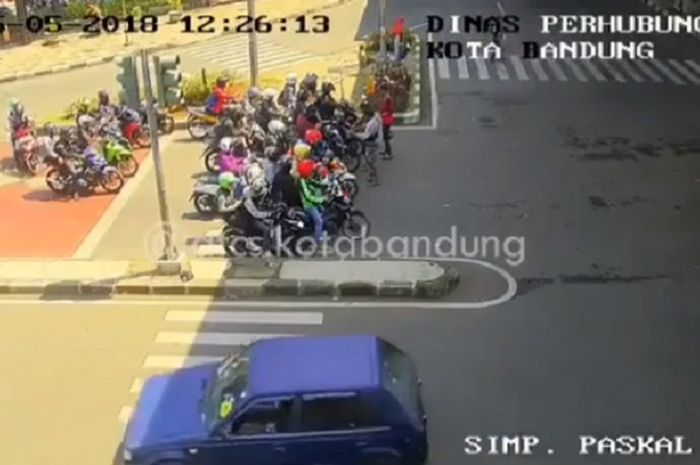 Pemotor berteduh dan berhenti di zebra cross 