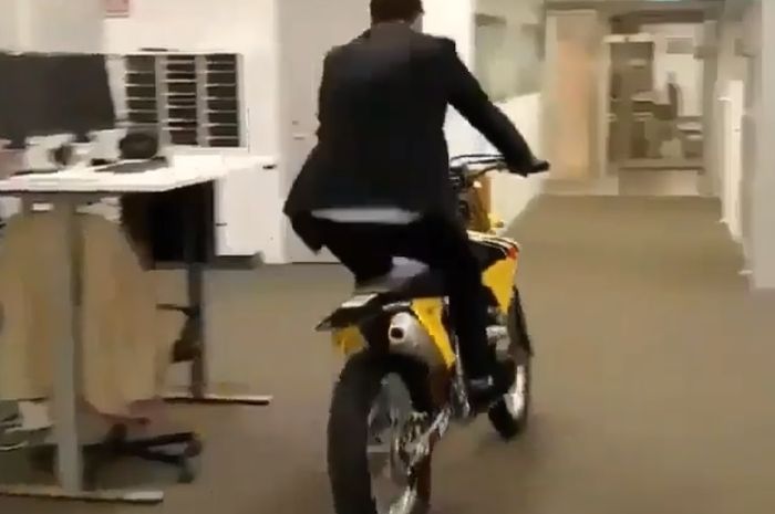 Pekerja kantor menggunakan motor trail di dalam ruangan