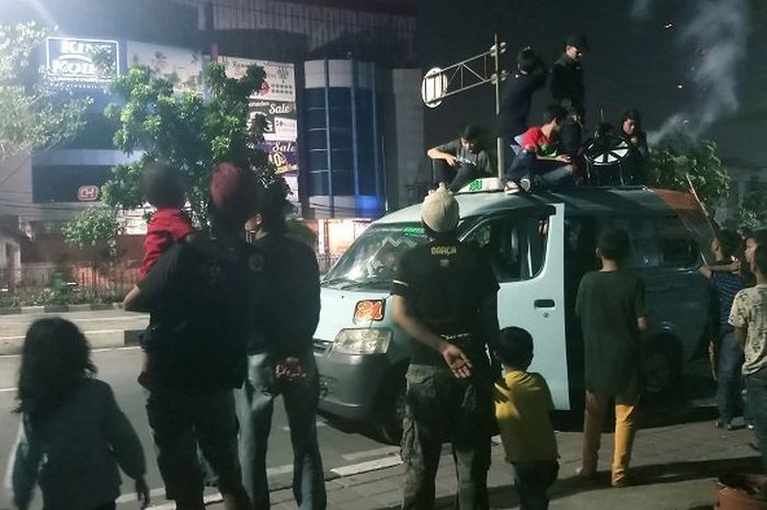 Sekelompok remaja konvoi takbir keliling menggunakan angkot dan melempar petasan ke arah pengendara lain di Jalan Pramuka, Jakarta Timur, Kamis (14/6/2018) malam.