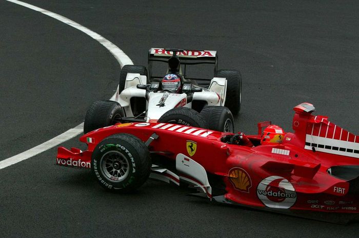 Pembalap Jepang Takuma Sato dengan mobil BAR-Honda menyundul mobil Ferrari andalan Michael Schumache