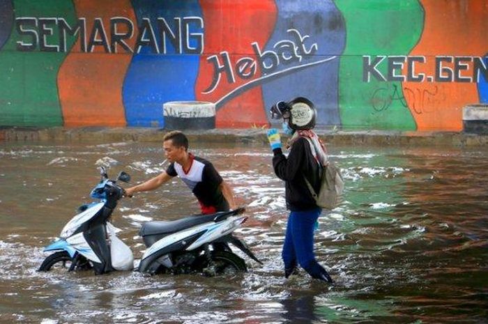 Warga membantu dorong motor yang mogok