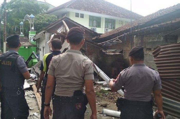 Polisi memeriksa tembok rumah yang roboh setelah ditabrak pikap