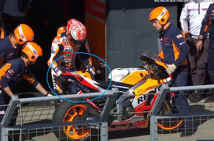 Marc Marquez memegang jok motornya yang rusak usai ditabrak Johann Zarco