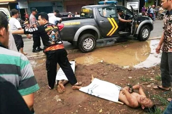 Polisi mengeluarkan dua orang lelaki yang dipergoki dalam kondisi telanjang di jok tengah mobil Suzuki Ertiga bernopol B 2254 KFB yang terpakir di depan pasar Trangkil, Kabupaten Pati, ?Kamis (20/12/2018) siang.
