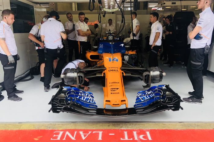 Kru tim McLaren tengan menangani mobl Fernando Alonso di GP F1 Austria