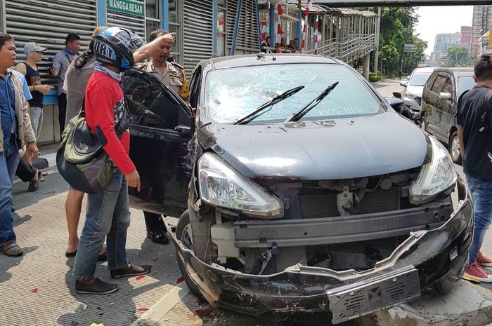 Nissan Grand Livina menabrak separator busway karena terlibat tabrak lari