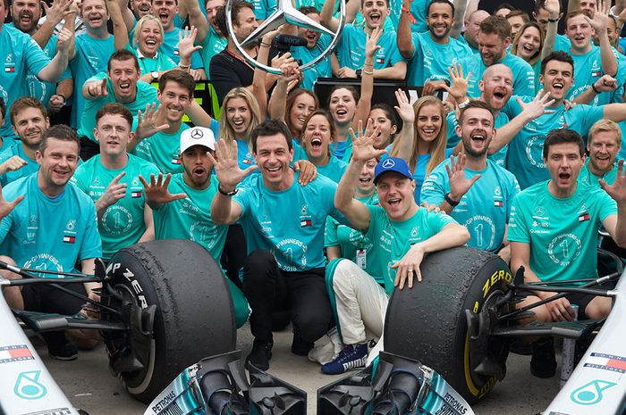 Toto Wolff (tengah) diapit Lewis Hamilton dan Valtteri Bottas bersama tim Mercedes merayakan juara F1 2018