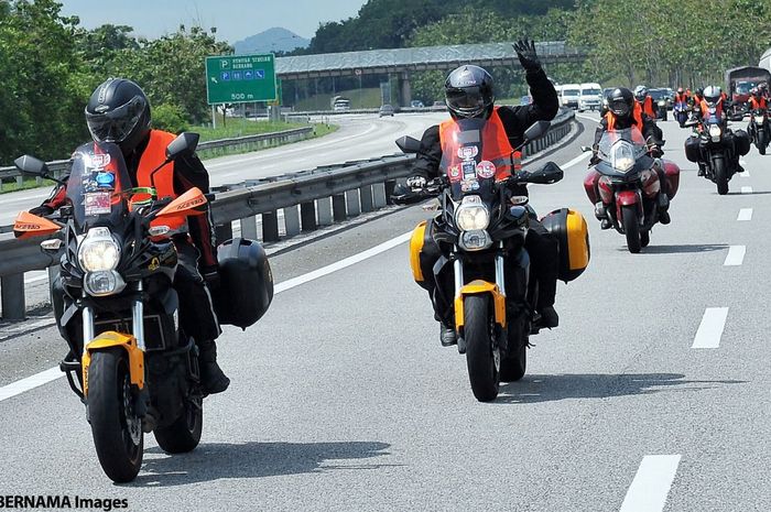 Ilustrasi pengendara motor melewati jalan tol di Malaysia