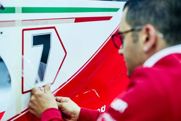 Kru tim Ferrari memasang nomor pada penutup mesin mobil Kimi Raikkonen menjelang balap F1 Spanyol 2017