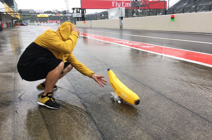 Kru tim Renault membuat perahu berbentuk pisang seperti banana boat dan diluncurkan di pit lane sirkuit Suzuka yang digenangi air