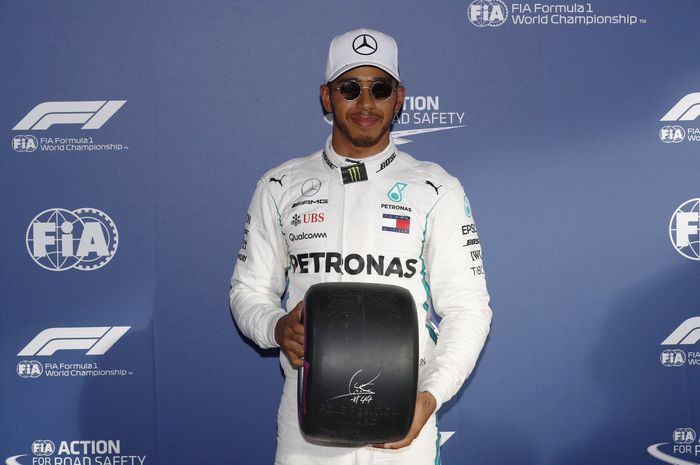Lewis Hamilton memegang hadian berupa ban Pirelli usai kualifikasi GP F1 Australia 2018