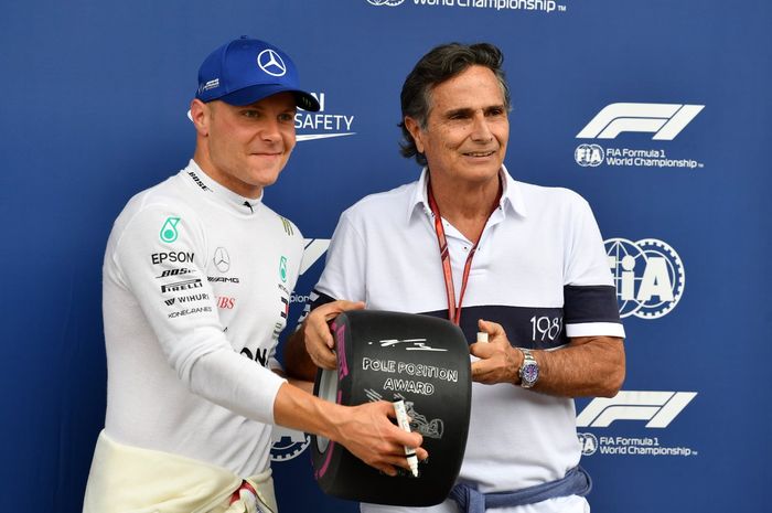 Valteri Bottas menerima trofi pole position GP F1 Austria dari Pirelli yang diserahkan oleh juara dunia tiga kali Nelson Piquet