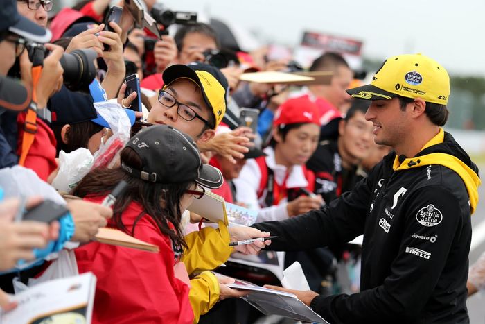 Pembalap tim Renault Carlos Sainz sibuk memberi tanda tangan kepada para fans yang datang ke Suzuka, hari Kamis ini