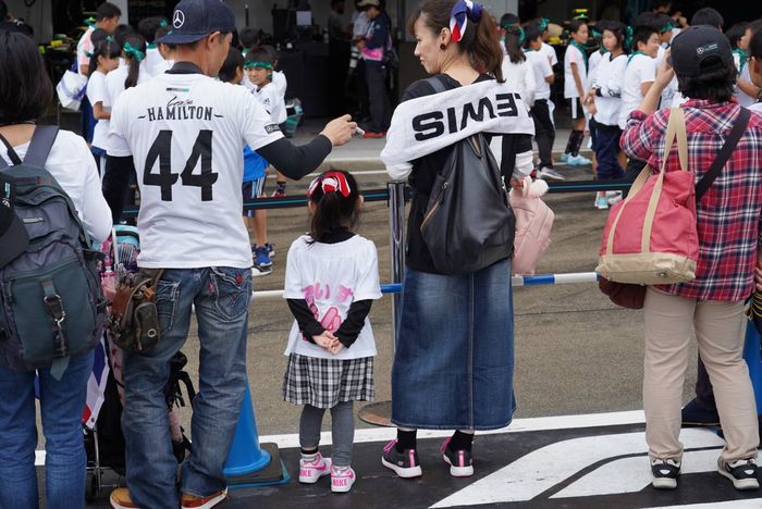 Pendukung Lewis Hamilton di depan garasi tim Mercedes di sirkuit Suzuka