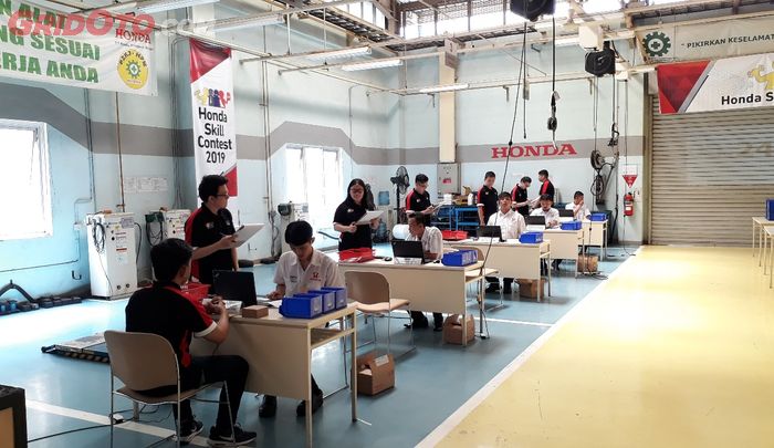 Para peserta kompetisi yang berasal dari divisi spare parts (duduk, seragam putih) tengah dinilai oleh para juri (berdiri)