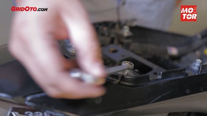 Lepaskan baut yang berada di bawah jok