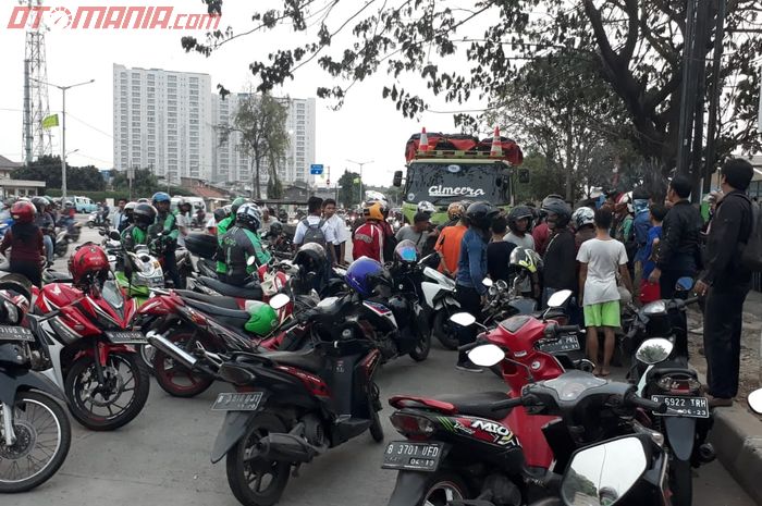 Kerumunan pemotor membantu belasan motor yang terjatuh