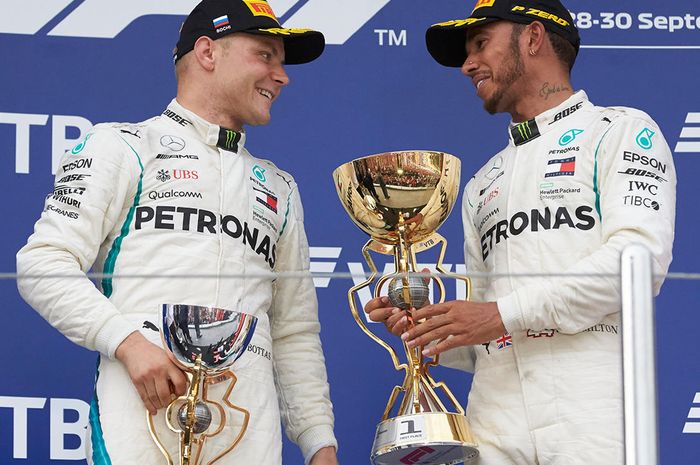 Lewis Hamilton sempat berbincang dengan Valtteri Bottas, seperti ingin memberi piala kemenangan GP F1 Rusia yang didapatnya lewat bantuan team order