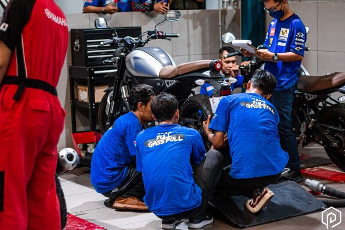 Para peserta menunjukkan kemampuan mekaniknya dalam permainan area bengkel di acara Yamaha Rewind Challenge.