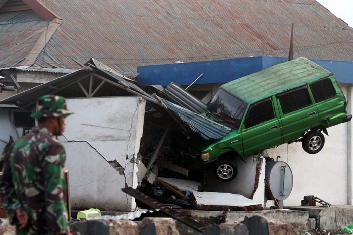 Toyota Kijang terbawa tsunami nyangkut di tembok bangunan