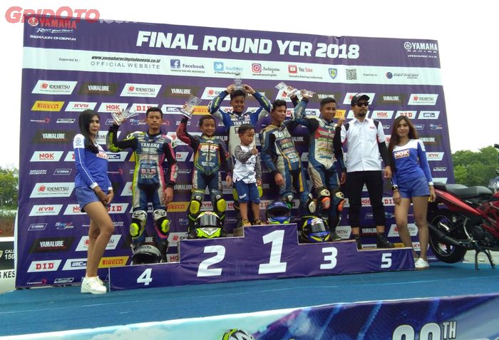 Aldy Satya Mahendra (P1) dan Nicky Hayden (P2) di podium kelas YCR5 pada final Yamaha Cup Race 2018, Mijen, Semarang, 