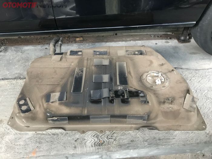 Sebelum tes isi, tangki BBM Nissan Serena dilepas untuk dikuras BBM