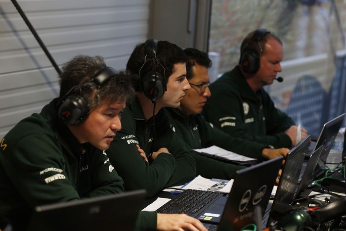Para kru tim Caterham F1 bekerja dengan laptop