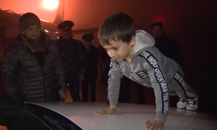 Rahim Kurayev melakukan push-up di atas mobil Mercedes-Benz