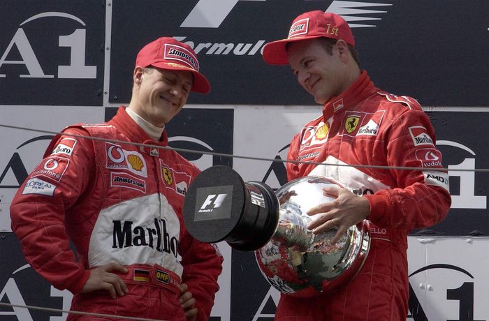 Michael Schumacher memberikan podium dan pialanya ke Barrichello di F1 Austria 2002