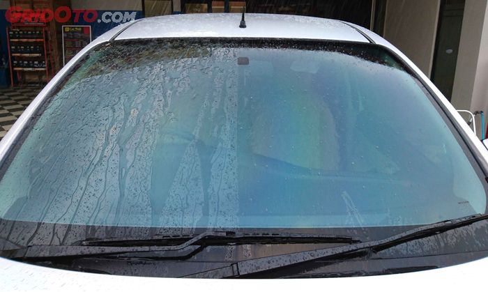 Ilustrasi aplikasi rain repellent di kaca depan mobil