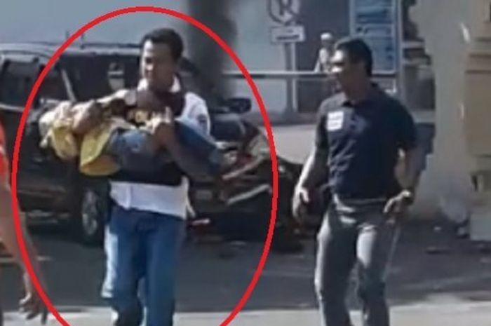 Seorang polisi menyelamatkan anak kecil usai ledakan bom di Polrestabes Surabaya.
