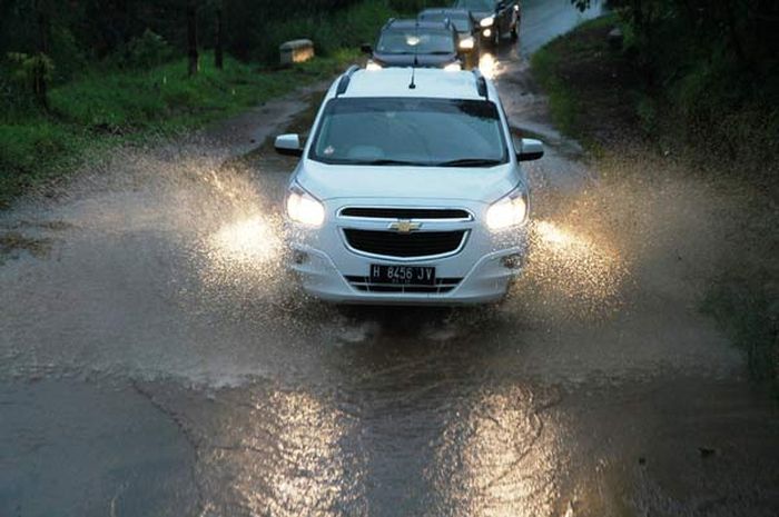 Ilustrasi mobil melintasi genangan air