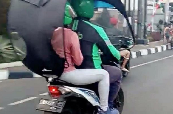 Ilustrasi penggunaan payung motor