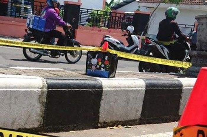 tas misterius di atas pembatas jalan