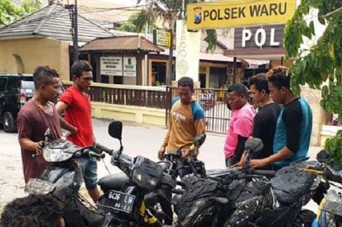 Warga dan polisi menurunkan motor setelah evakuasi di Polsek Waru, Minggu (21/10/2018).