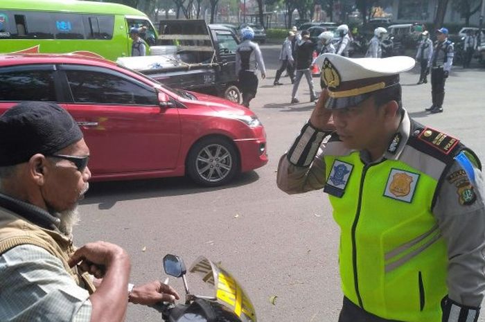 Seorang petugas polisi menegur pengendara tuna wicara 