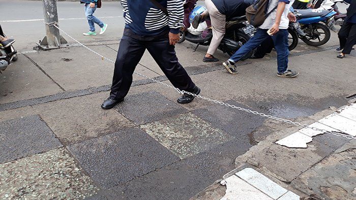 Cara polisi menghalau pemotor yakni dengan memasang rantai di trotoar tersebut.