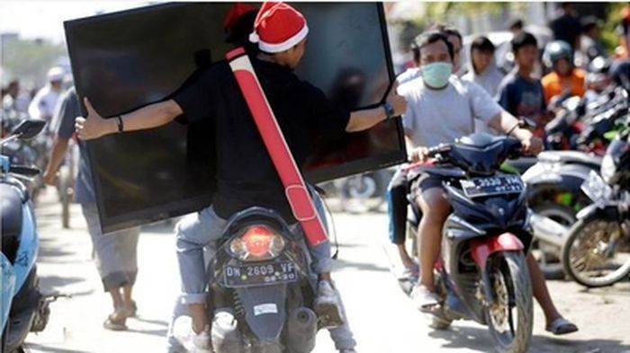 Tsunami di Palu: Penjarahan di Palu dari Sembako Hingga LED Layar Lebar Itu Jadi Berita Media Asing, tampak pengendara sepeda motor membawa LED   Artikel ini telah tayang di sripoku.com dengan judul Foto-Foto Penjarahan Pasca Tsunami di Palu, Mulai Toko, Mall Hingga ATM pun Jadi Sasaran,