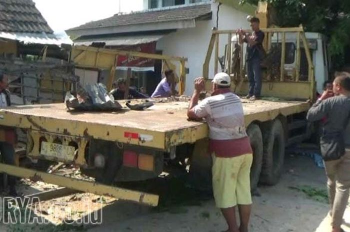 Sebuah truk crane menabrak sebuah rumah dan warung milik warga