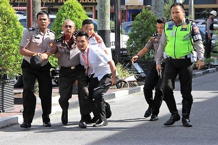 Seorang polisi terluka dan dibopong rekannya di Mapolda Riau, Selasa (16/5/2018).   