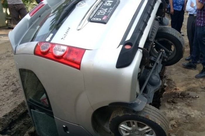 Mobil Daihatsu Xenia B 1304 BFW nyemplung ke dalam lubang berukuran besar di Tanjung Duren, Grogol Petamburan, Jakarta Barat,  (27/5/2018)