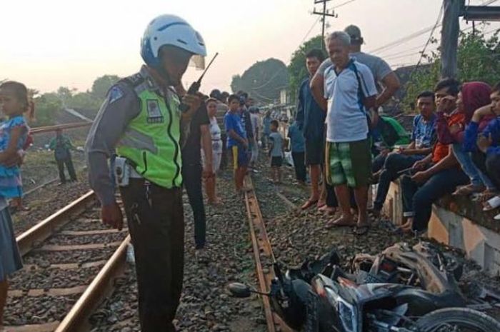 Petugas mengevakuasi motor Honda BeAT milik pengendara ojek online yang terseret kereta api di Semarang Tengah