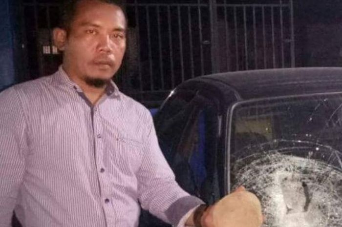 Wartawan media online, Arif Tampubolon menunjukkan batu yang dilemparkan dua OTK.