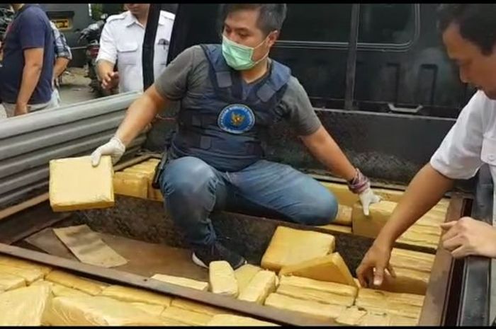 Petugas Badan Narkotika Nasional (BNN) membongkar bagian bawah bak mobil pikap yang dijadikan tempat menyembunyikan ratusan paket ganja seberat 250 kilogram, Rabu (17/10/2018). 