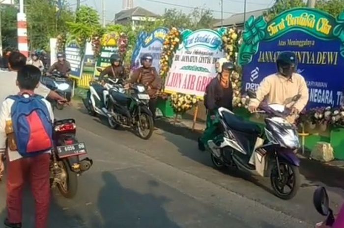 Pemotor menuntun motornya saat lewati rumah duka korban pesawat Lion Air JT 610